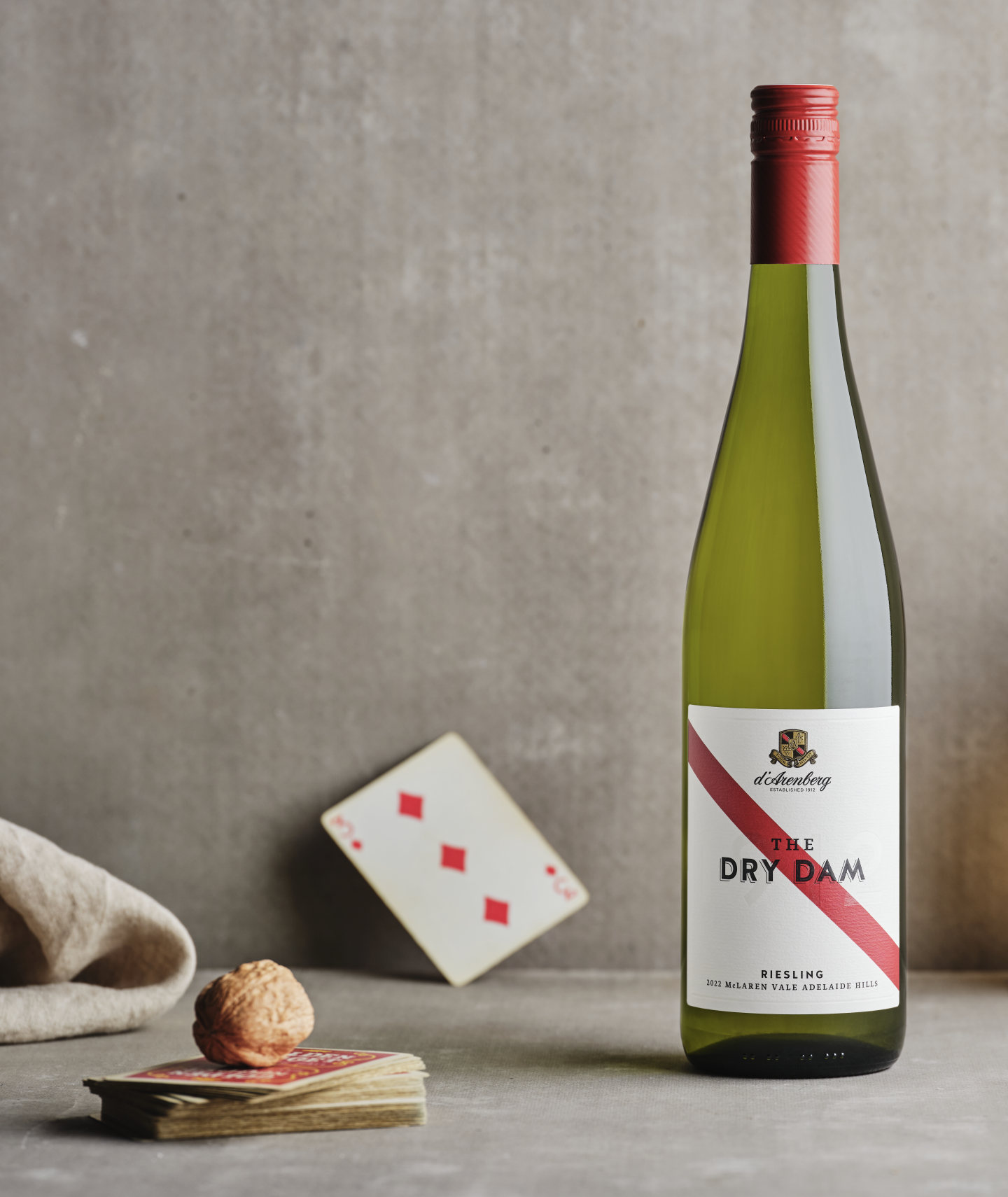 A bottle of The Dry Dam Riesling wine by d’Arenberg, a wine label with a red stripe sitting on a table