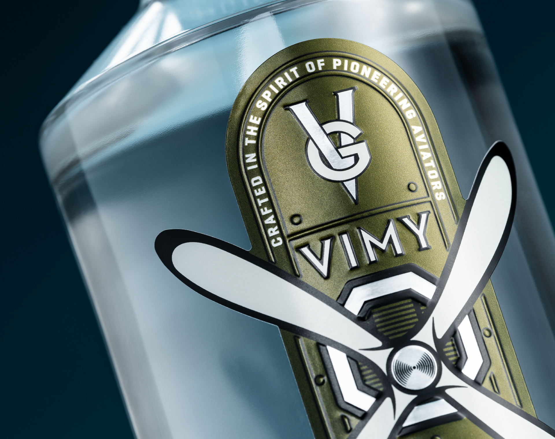 A close up photograph of a Vimy Gin bottle featuring an aviation themed label on pressed metal label stock with metallic and embossing effects.