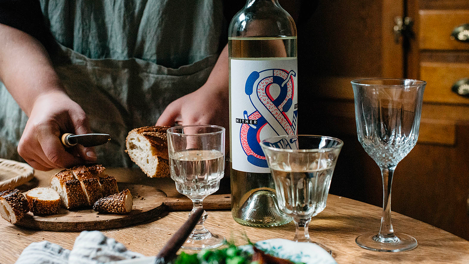 Bottle of Hither & Yon wine sitting on a table next to wine glasses and tasting plate