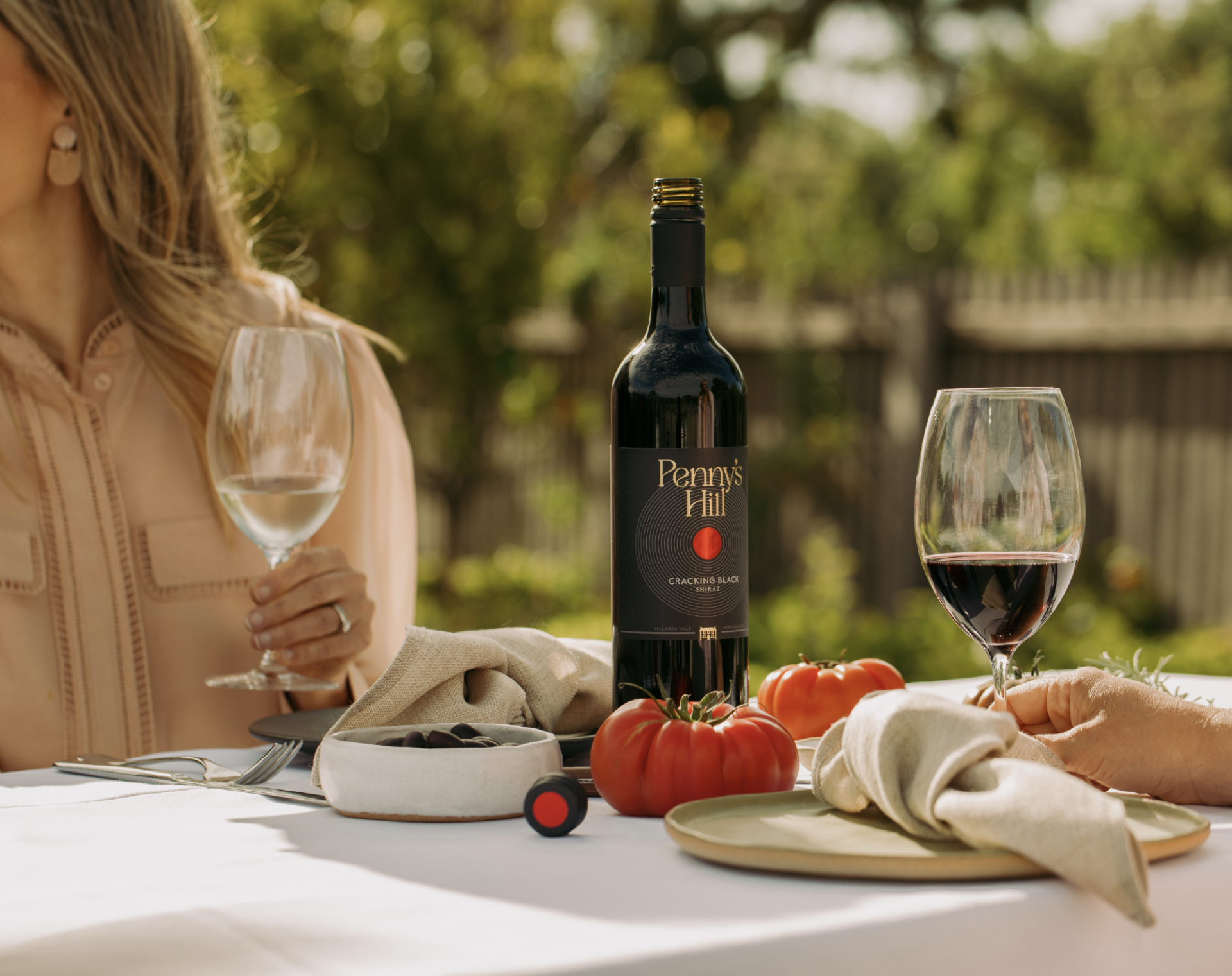 Lifestyle image showing a couple enjoying a bottle of wine from  Penny's Hill Homestead range. 