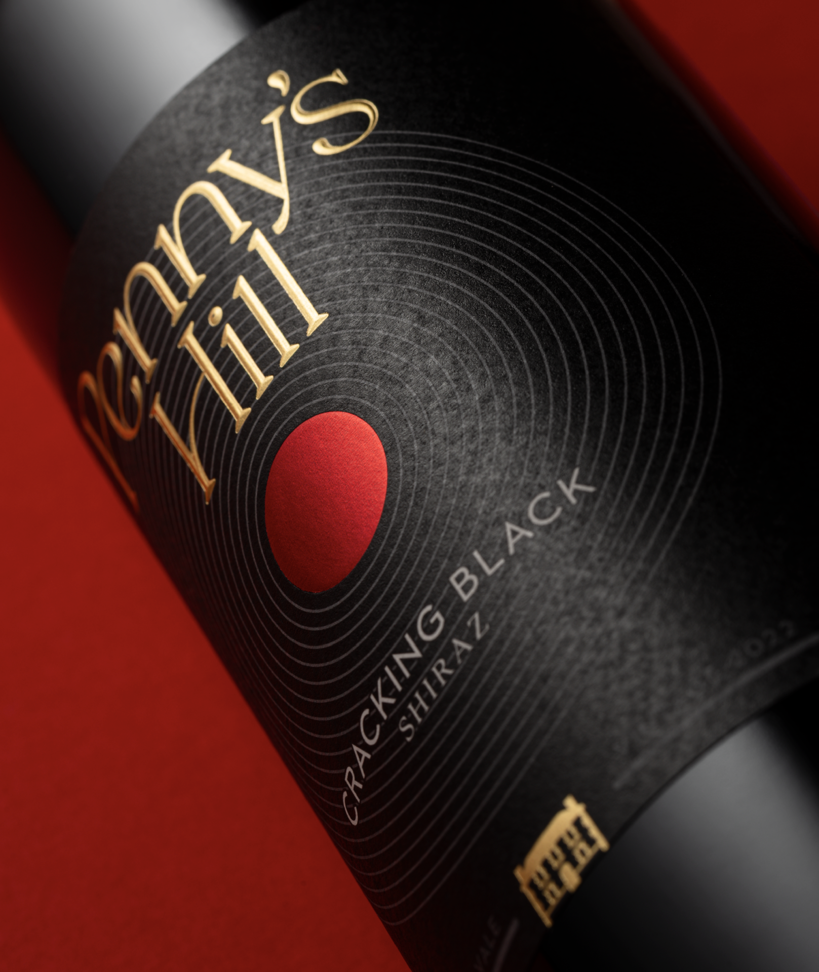 Close up detail of Cracking Black wine label design showing the Penny's Hill logotype and red foiled dot.