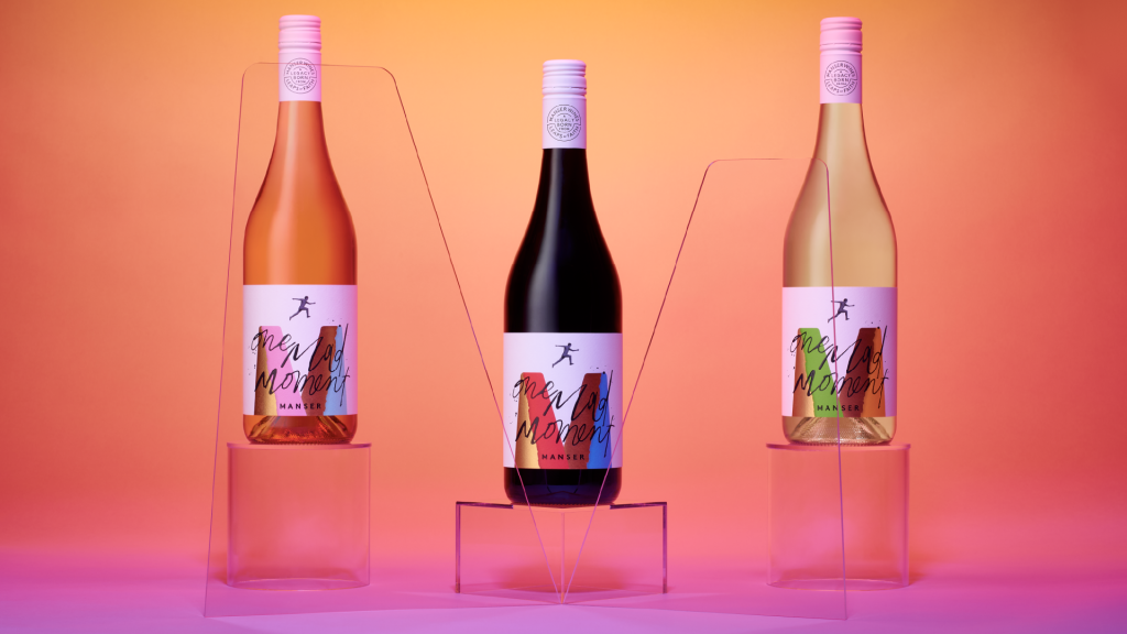 Three colourful Manser Wines One Mad Moment bottles with expressive handwritten typography and bright foil wine labels designed by Voice Design.