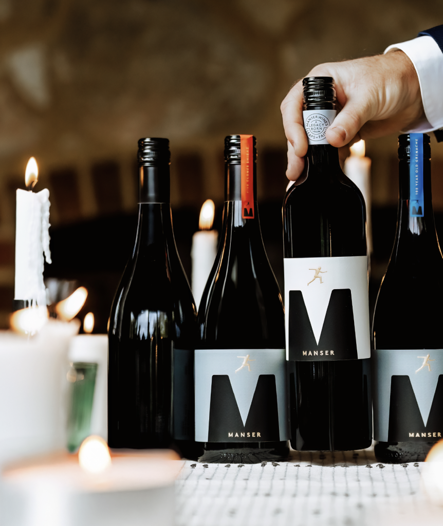 Three bottles of Manser Wines displayed on a table, highlighting wine label differentiation and premium packaging design for a family-owned wine brand.