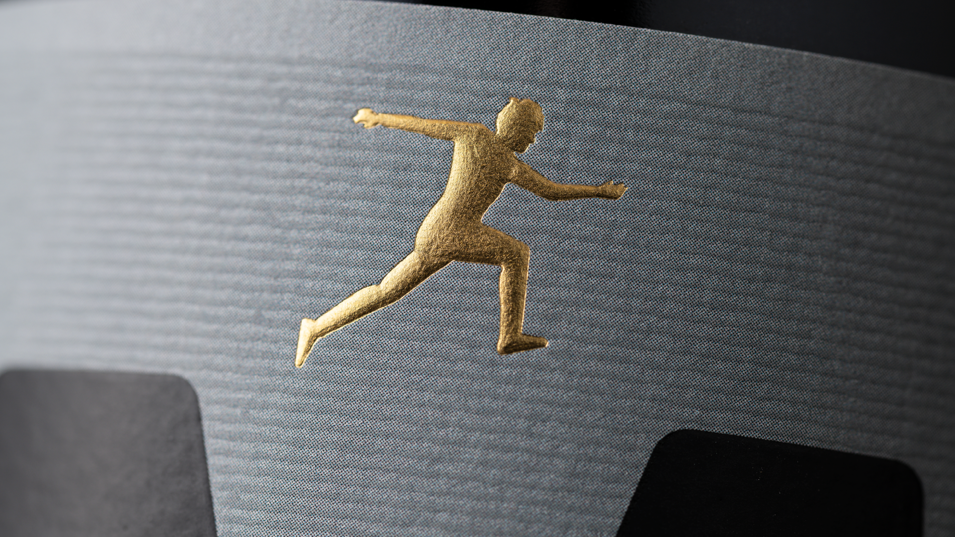 Gold sculptural emboss of a leaping figure on a dark premium wine label for the Manser Wines Estate Range, showcasing luxury wine packaging and refined label design.