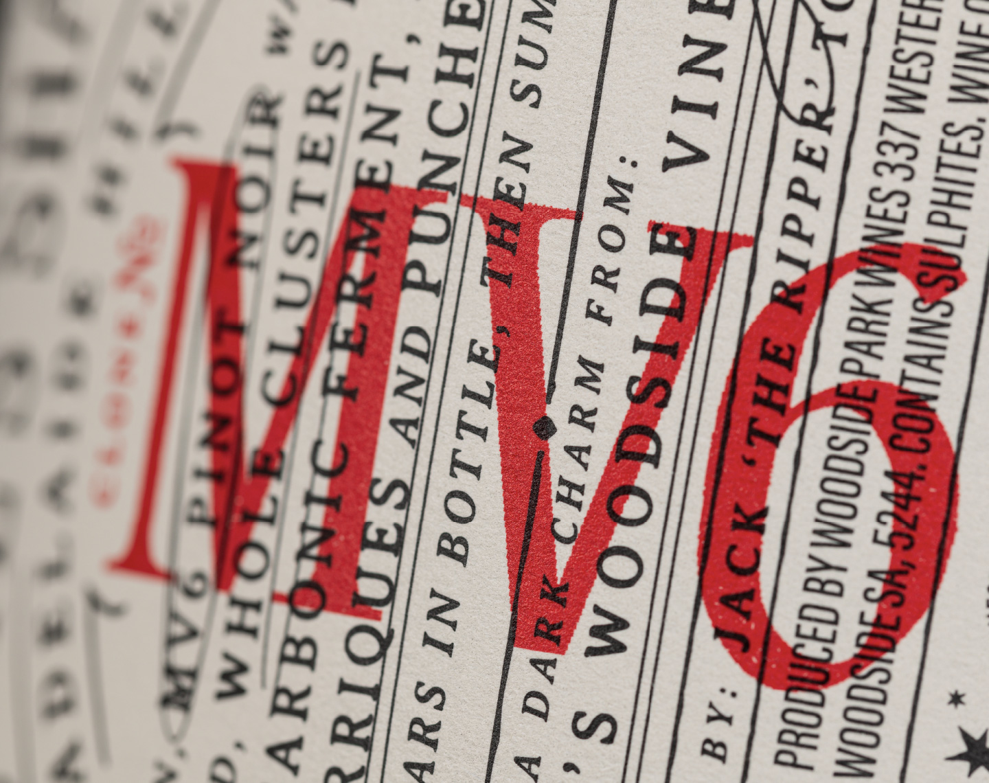 Extreme close-up of the back label design for The Devil Made Pinot Single Clone, showcasing crisp typography, premium textured paper stock, and high-quality red ink overprinting.