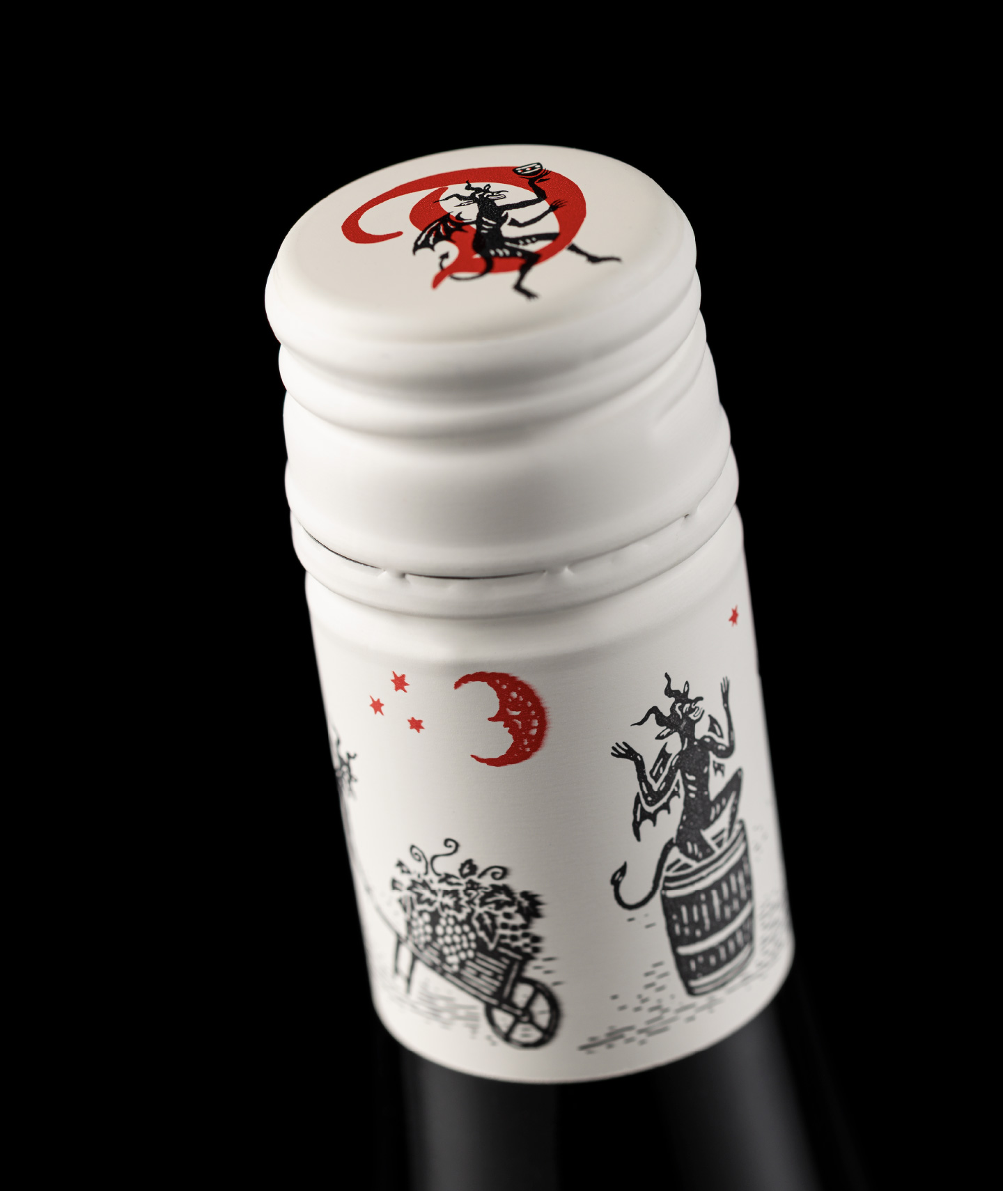 Close-up of the custom wine bottle capsule for The Devil Made Pinot, showcasing bespoke devil illustrations, crescent moon motifs, and premium branding.